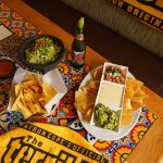 FootballR - NFL - Diese Beschreibung wurde automatisch generiert. Guacamole, Chips und Salsa auf einem Tisch.