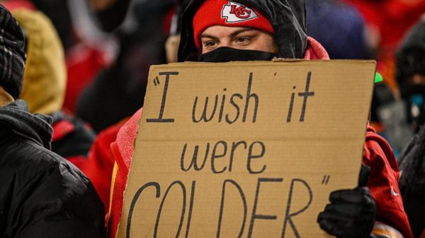 FootballR - NFL - In Kansas City hält ein Mann ein Schild hoch, auf dem er seinen Wunsch nach kälteren Temperaturen zum Ausdruck bringt.