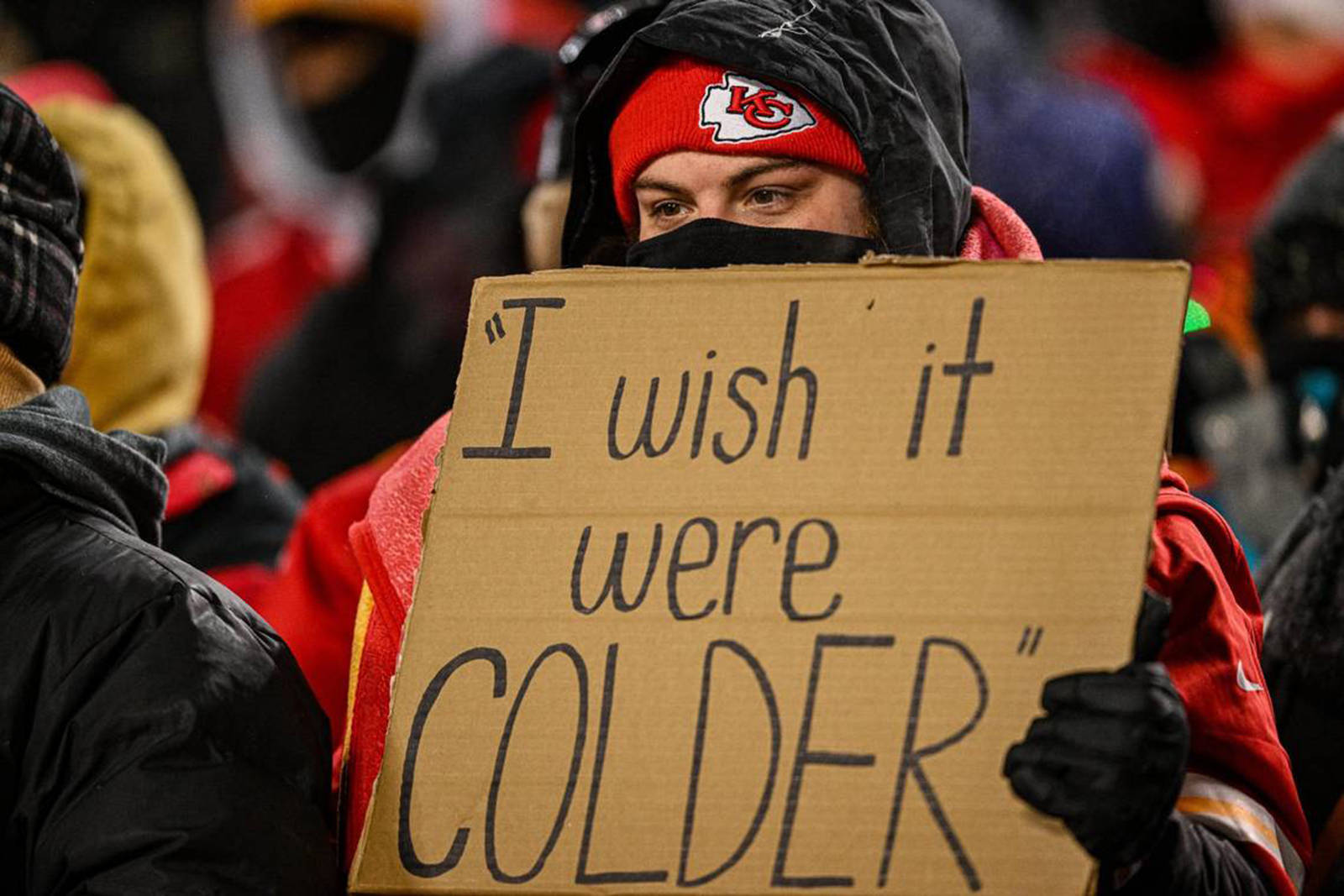 FootballR - NFL - In Kansas City hält ein Mann ein Schild hoch, auf dem er seinen Wunsch nach kälteren Temperaturen zum Ausdruck bringt.