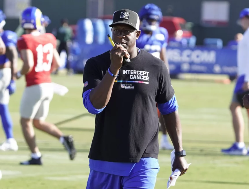 FootballR - NFL - Diese Beschreibung wurde automatisch generiert. Raheem Morris, der Cheftrainer der Atlanta Falcons, trägt ein schwarzes Hemd.