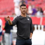 FootballR - NFL - Diese Beschreibung wurde automatisch generiert. Cheftrainer Dave Canales deutet auf einen Spieler hin, der für Carolina in der NFL auf dem Feld steht.