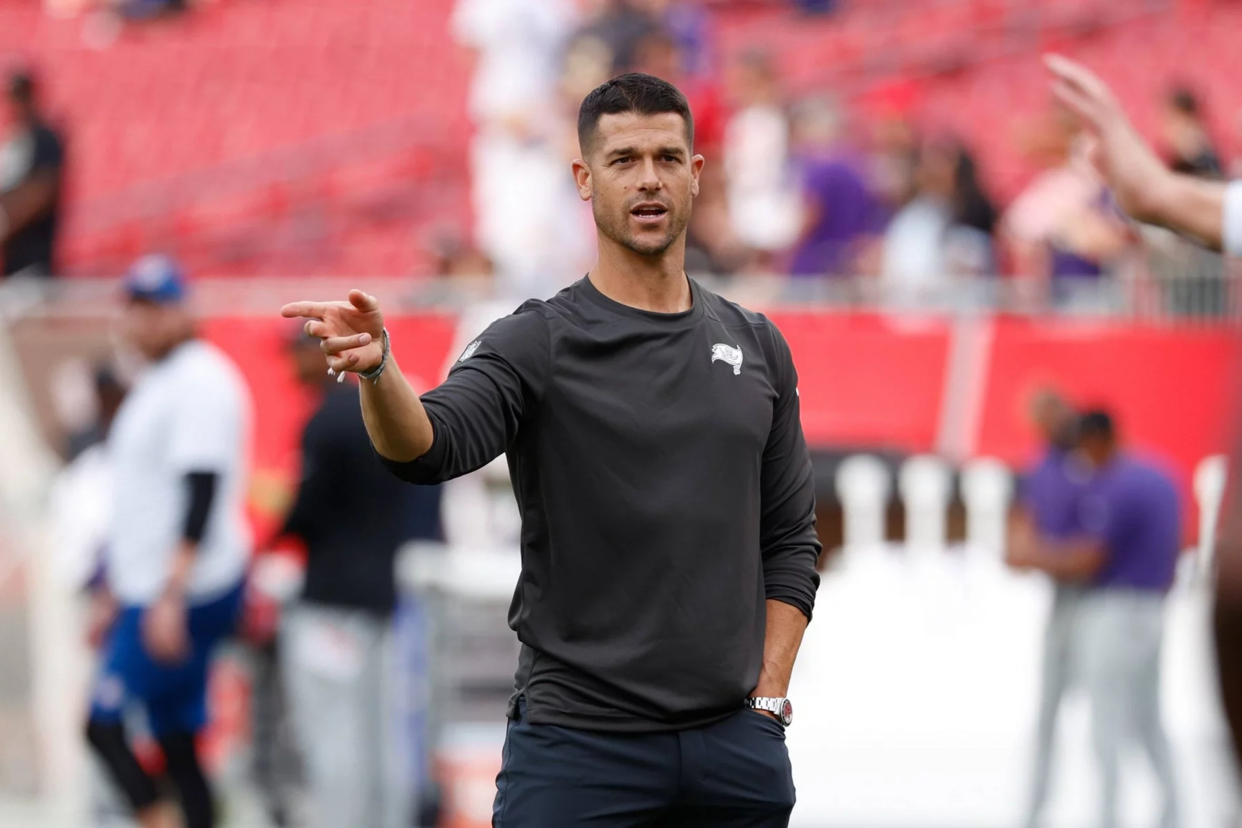 FootballR - NFL - Diese Beschreibung wurde automatisch generiert. Cheftrainer Dave Canales deutet auf einen Spieler hin, der für Carolina in der NFL auf dem Feld steht.