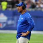 FootballR - NFL - Diese Beschreibung wurde automatisch generiert. Der Defensive Coordinator der Chicago Bears, Eric Washington, steht auf dem Spielfeld.