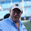 FootballR - NFL - David Tepper, der Besitzer der NFL Panthers, trägt ein blaues Hemd und eine Mütze und ist auf einem Footballfeld zu sehen.