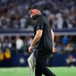 FootballR - NFL Woche 15 - Der Cheftrainer der Detroit Lions, Dan Campbell, der ein NFL-Team vertritt, geht selbstbewusst über das Spielfeld und regt sich über ein ruling zu ineligible Players auf