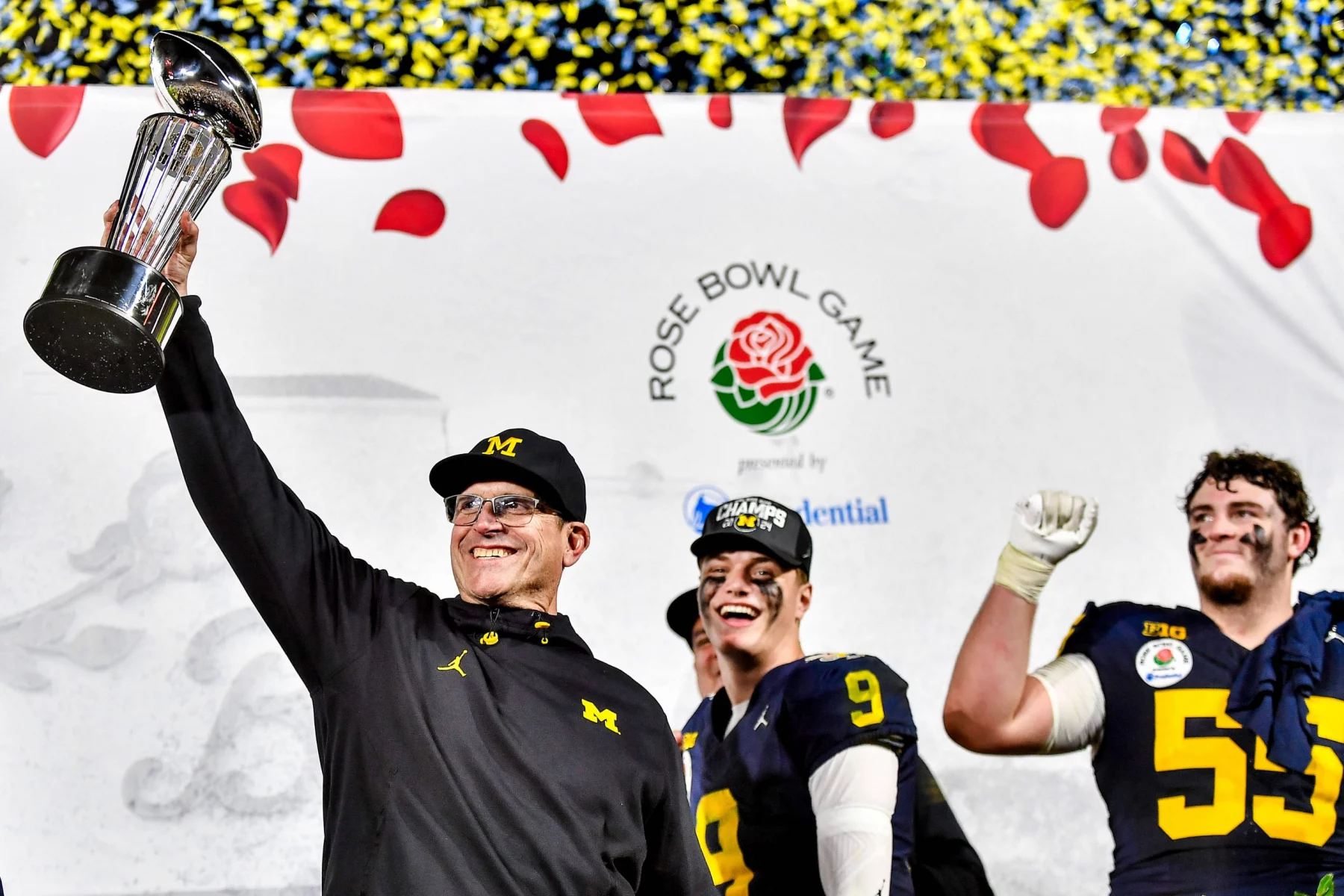 FootballR - NFL - Jim Harbaugh - Die Footballspieler der Michigan Wolverines heben triumphierend die Rose Bowl Trophäe in die Höhe.