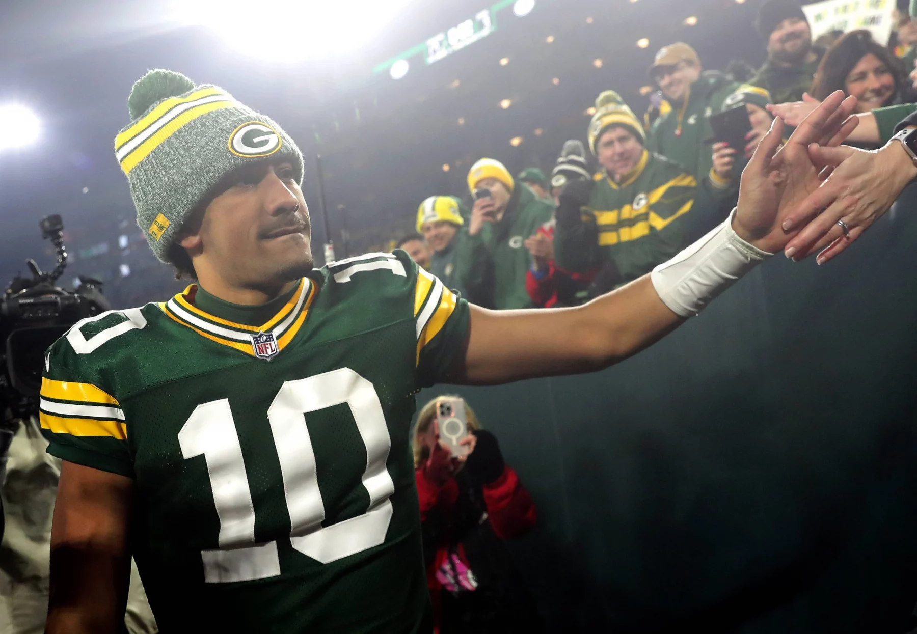 FootballR - NFL Playoff Plätze - Ein Spieler der Packers schüttelt den Fans die Hand.
