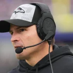 FootballR - NFL - Diese Beschreibung wurde automatisch generiert. Der Head Coach der Seahawks, Mike Macdonald, trägt ein Headset.