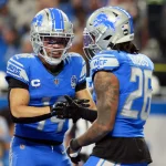 Bye Week Woche 8 - DAZN NFL - Zwei Footballspieler der Detroit Lions in blauen und silbernen Uniformen treten in einem dramatischen Wild Card Game gegen die Rams an. Amon-Ra St. Brown