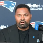 FootballR - NFL - Jerod Mayo, ein Spieler der Patriots, spricht in ein Mikrofon.