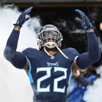 FootballR - NFL - Diese Beschreibung wurde automatisch generiert. Ein Titans-Spieler in einer blauen Uniform, steht vor Rauch. Gibt es die Derrick Henry Rückkehr ins Team?