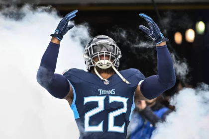 FootballR - NFL - Diese Beschreibung wurde automatisch generiert. Ein Titans-Spieler in einer blauen Uniform, steht vor Rauch. Gibt es die Derrick Henry Rückkehr ins Team?