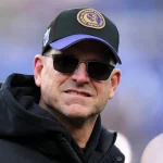 FootballR - NFL - Der Coach der Michigan Wolverines, Jim Harbaugh, trägt eine Sonnenbrille. Wechsel zu den Chargers?