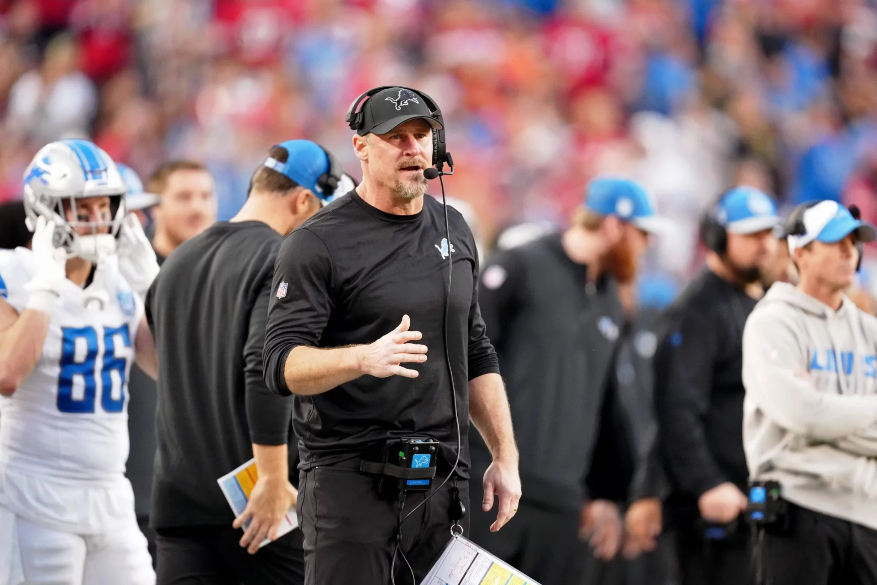 FootballR - NFL - Diese Beschreibung wurde automatisch generiert. Dan Campbell, ein Trainer der Detroit Lions, am Spielfeldrand während eines Spiels.