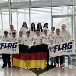 FootballR - NFL - Diese Beschreibung wurde automatisch generiert. Eine Gruppe von Menschen posiert für ein Foto mit einer deutschen Flagge, die ein Flag Football Team repräsentiert.