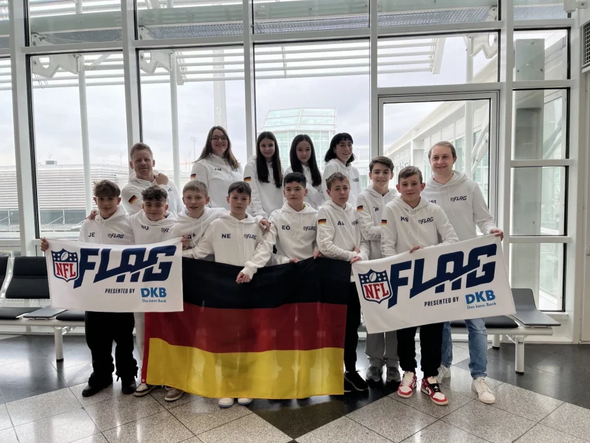 FootballR - NFL - Diese Beschreibung wurde automatisch generiert. Eine Gruppe von Menschen posiert für ein Foto mit einer deutschen Flagge, die ein Flag Football Team repräsentiert.