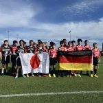FootballR - NFL - Diese Beschreibung wurde automatisch generiert. Eine Gruppe Fußballspieler posiert mit einer deutschen Flagge.