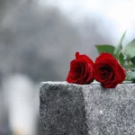 FootballR - NFL - Diese Beschreibung wurde automatisch generiert. Auf dem Grabstein von Tony Hutson sind zwei rote Rosen platziert.