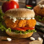 FootballR - NFL - Diese Beschreibung wurde automatisch generiert. Zwei Buffalo Chicken Slider auf einem Holzschneidebrett, perfekt für Slider Mania oder Super Bowl Fest.