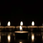 FootballR - NFL - Golden Richards - Diese Beschreibung wurde automatisch generiert. Eine Reihe flackernder Kerzen auf dunklem Hintergrund.