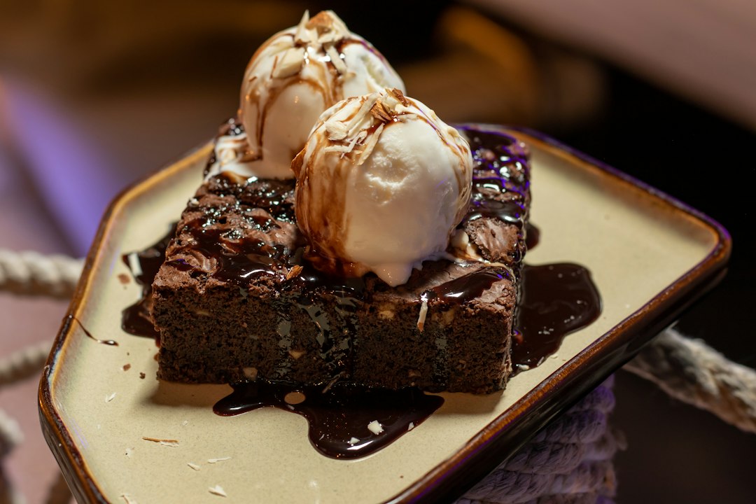 FootballR - NFL - Diese Beschreibung wurde automatisch generiert. Ein Brownie mit Eis auf einem Teller.