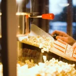 FootballR - NFL - Diese Beschreibung wurde automatisch generiert. Eine Person füllt Popcorn in eine Maschine.