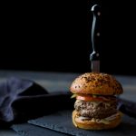FootballR - NFL - Diese Beschreibung wurde automatisch generiert. Ein Burger mit einem Messer darauf.