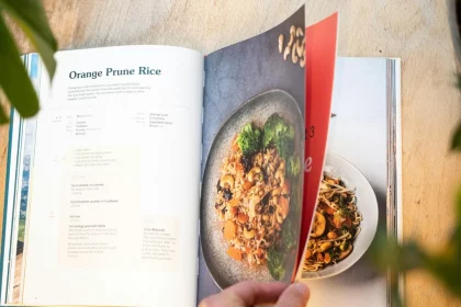 FootballR - NFL - Diese Beschreibung wurde automatisch generiert. Eine Person hält ein Buch mit einem Bild von Lebensmitteln.