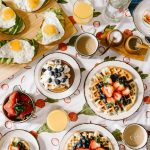 FootballR - NFL - Diese Beschreibung wurde automatisch generiert. Waffeln, Eier, Obst und Saft auf einer Tischdecke.