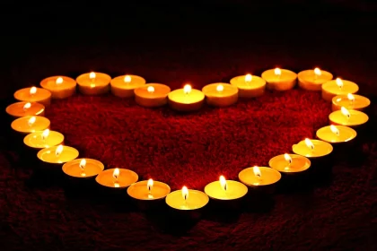 FootballR - NFL - Trauerfeier - Diese Beschreibung wurde automatisch generiert. Eine herzförmige Kerze mit brennenden Kerzen wird häufig bei Beerdigungen oder Gedenkfeiern zu Ehren eines Todesopfers verwendet.