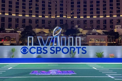 FootballR - NFL - Diese Beschreibung wurde automatisch generiert. Das CBS-Sportlogo befindet sich auf einem Footballfeld in Las Vegas. Super Bowl LVIII Tipping Game