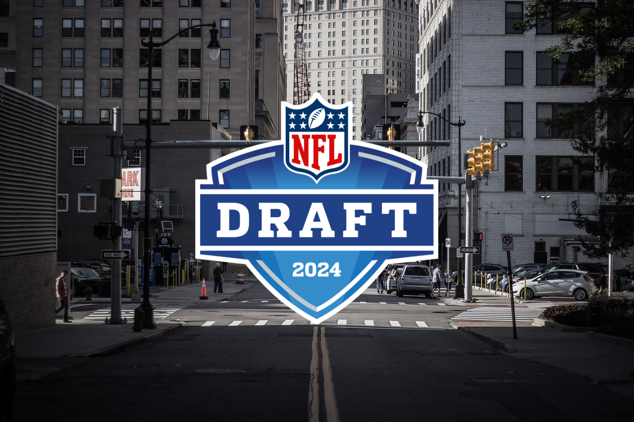 FootballR - NFL - sechs Quarterbacks -Compensatory Picks 2024 - Diese Beschreibung wurde automatisch generiert. Das Logo des NFL Draft 2024 war während des Auswahlverfahrens der ersten Runde prominent auf einer Straße in der Stadt Detroit zu sehen.