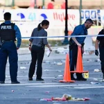 FootballR - NFL - Diese Beschreibung wurde automatisch generiert. Super Bowl Parade: Eine Gruppe Polizisten steht in der Nähe des Tatorts einer Schießerei.