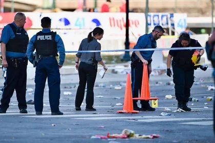 FootballR - NFL - Diese Beschreibung wurde automatisch generiert. Super Bowl Parade: Eine Gruppe Polizisten steht in der Nähe des Tatorts einer Schießerei.