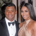 FootballR - NFL - Diese Beschreibung wurde automatisch generiert. Ein Mann, Russell Wilson, und seine Frau Ciara posieren für ein Foto in Denver.