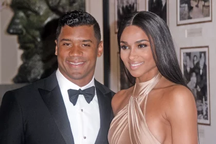 FootballR - NFL - Diese Beschreibung wurde automatisch generiert. Ein Mann, Russell Wilson, und seine Frau Ciara posieren für ein Foto in Denver.