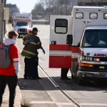 FootballR - NFL Super-Bowl-Parade - Diese Beschreibung wurde automatisch generiert. Eine Gruppe Jugendlicher steht neben einem Krankenwagen auf einer Straße.