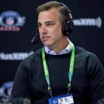 FootballR - NFL - Diese Beschreibung wurde automatisch generiert. Ein Mann, der mit Kopfhörern vor einem Mikrofon sitzt, Daniel Jeremiah.