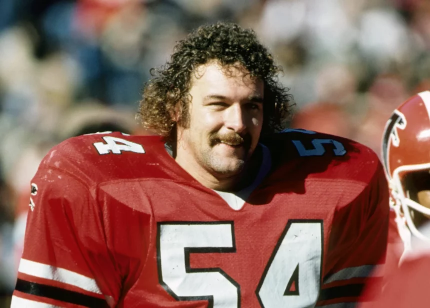 FootballR - NFL - Diese Beschreibung wurde automatisch generiert. Eine Falcons-Legende, Fulton Kuykendall, mit roter Uniform.