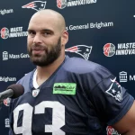 FootballR - NFL - Diese Beschreibung wurde automatisch generiert. Ein NFL-Spieler steht vor einem Mikrofon. Guy und Phillips