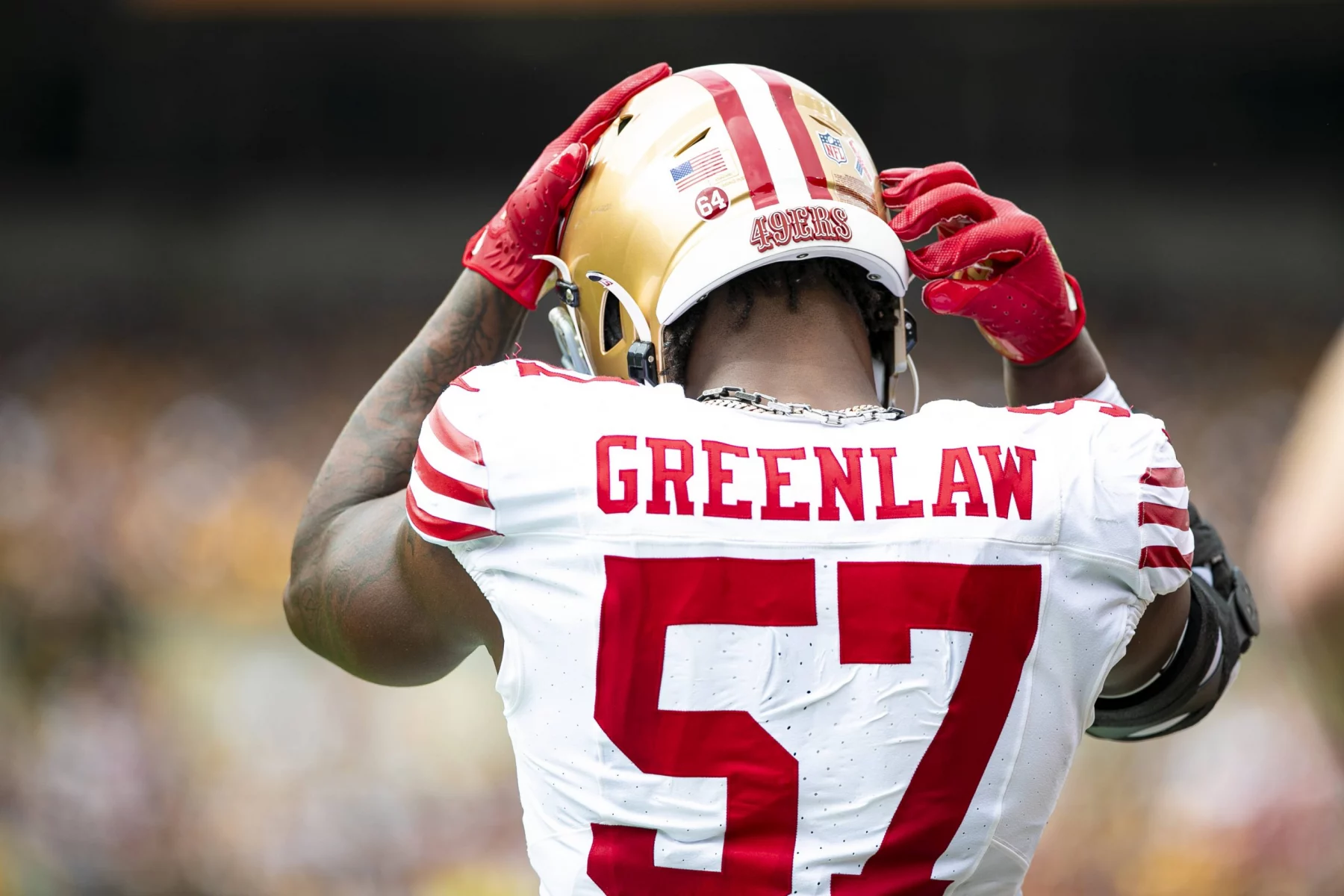 FootballR - NFL - Diese Beschreibung wurde automatisch generiert. Dre Greenlaw, von den San Francisco 49ers, trägt einen Helm.