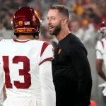 FootballR - NFL - Diese Beschreibung wurde automatisch generiert. Kliff Kingsbury und Caleb Williams unterhalten sich auf dem Spielfeld.