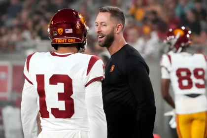 FootballR - NFL - Diese Beschreibung wurde automatisch generiert. Kliff Kingsbury und Caleb Williams unterhalten sich auf dem Spielfeld.