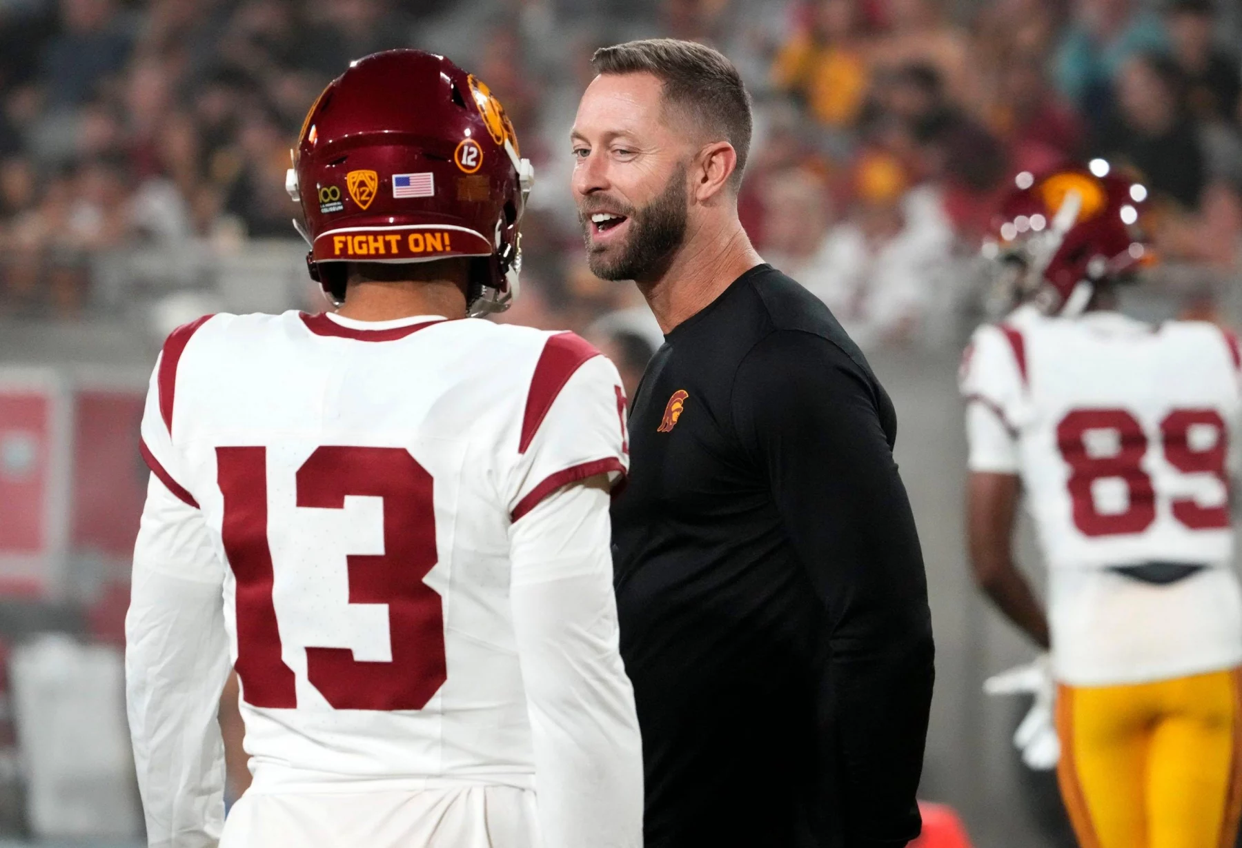 FootballR - NFL - Diese Beschreibung wurde automatisch generiert. Kliff Kingsbury und Caleb Williams unterhalten sich auf dem Spielfeld.