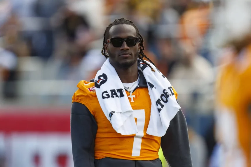 FootballR - NFL - Diese Beschreibung wurde automatisch generiert. Ein Quarterback der University of Tennessee, Joe Milton III, trägt Sonnenbrille und Schal.
