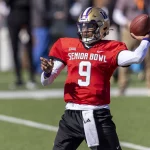 FootballR - NFL - Diese Beschreibung wurde automatisch generiert. Michael Penix Jr. wirft einen Football auf das Spielfeld.