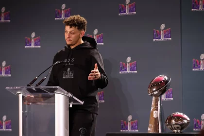 FootballR - NFL - Diese Beschreibung wurde automatisch generiert. Ein Mann, Patrick Mahomes, steht mit einer Trophäe vor sich auf einem Podium und feiert den Sieg im Super Bowl LVIII mit rekordverdächtiger Zuschauerzahl.