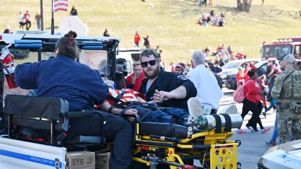 FootballR - NFL - Diese Beschreibung wurde automatisch generiert. Tödliche Schießerei - Eine Gruppe von Verletzten sitzt auf der Ladefläche eines Krankenwagens bei der Parade der Chiefs.
