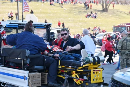FootballR - NFL - Diese Beschreibung wurde automatisch generiert. Tödliche Schießerei - Eine Gruppe von Verletzten sitzt auf der Ladefläche eines Krankenwagens bei der Parade der Chiefs.