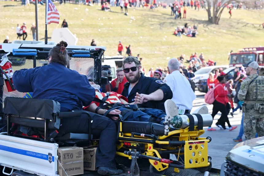 FootballR - NFL - Diese Beschreibung wurde automatisch generiert. Tödliche Schießerei - Eine Gruppe von Verletzten sitzt auf der Ladefläche eines Krankenwagens bei der Parade der Chiefs.